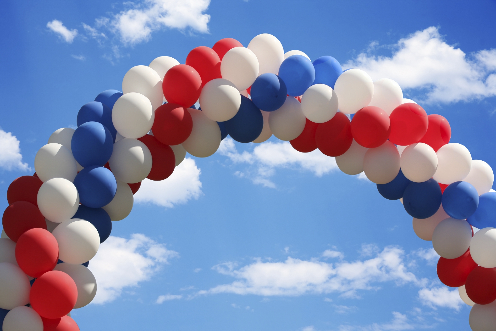Beautiful blue heavenly and soft cloudy sky with a patriotic balloon arch