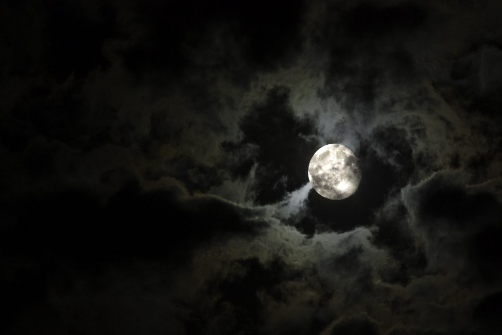 Full moon and eerie white clouds against a black sky